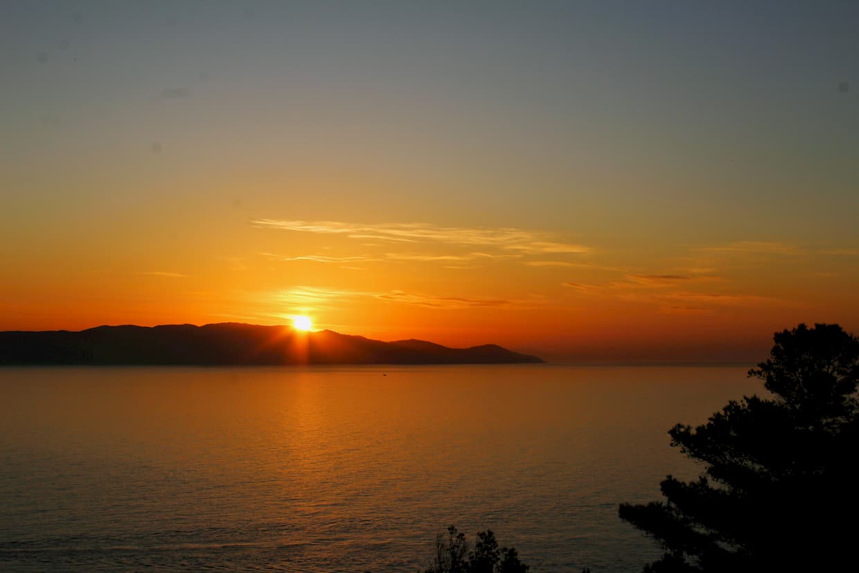 Sun setting behind an island.