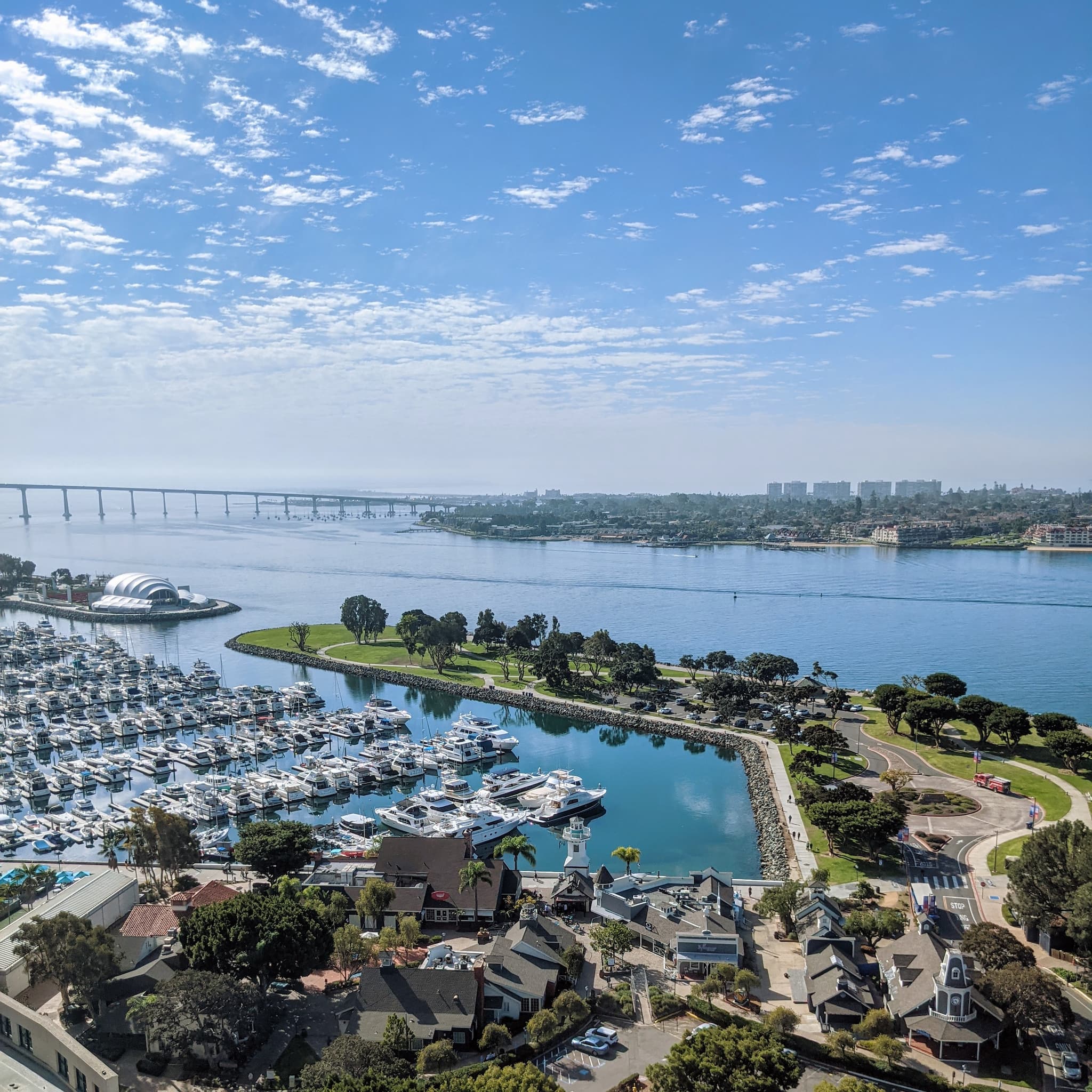 view looking over a marina to a large bay with a bridge and land across the water.