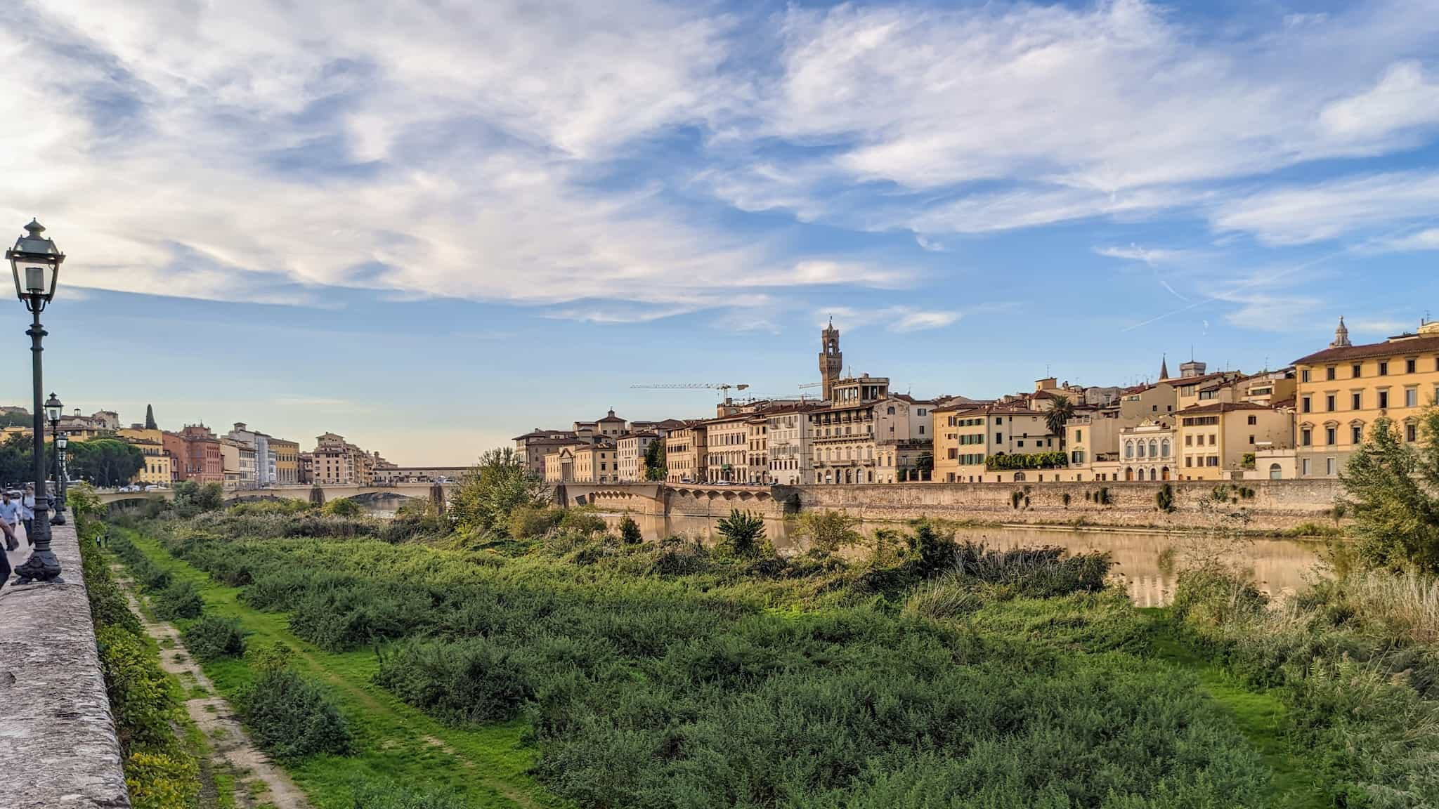 Low lying grassy area along a river in a old stone city.