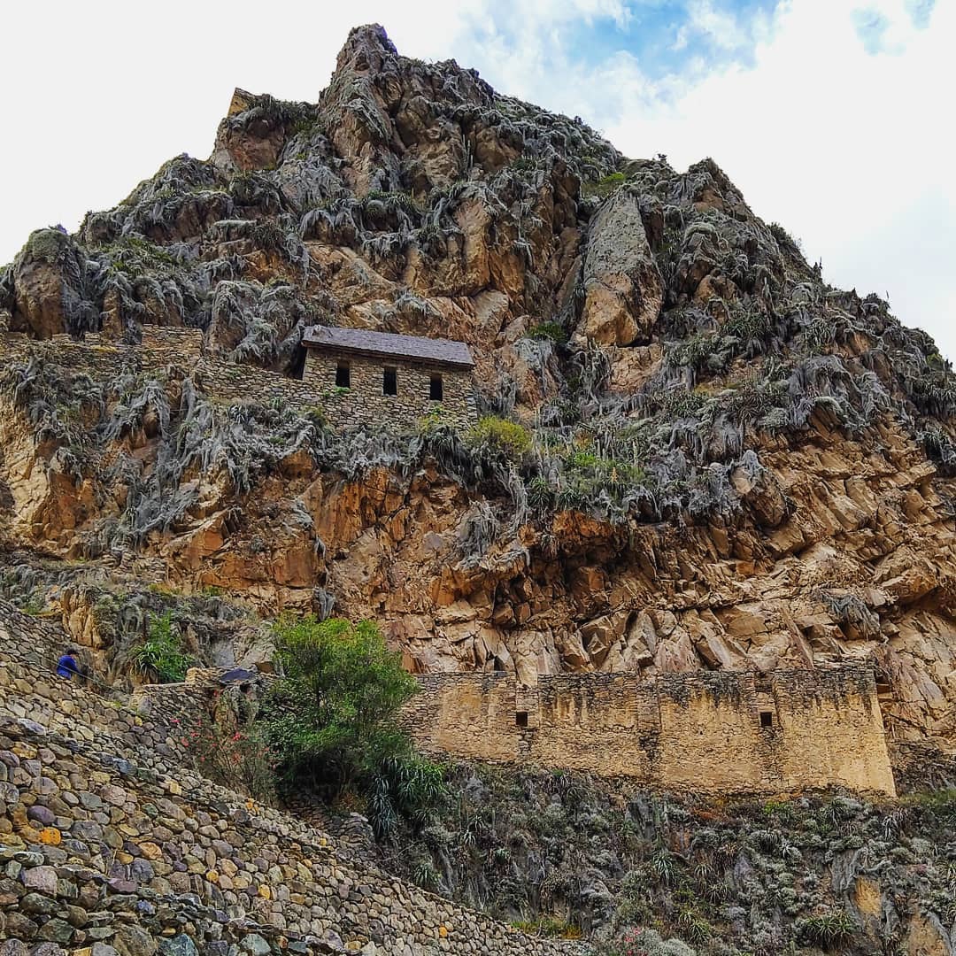 Rocky hillside with historic stone walls and buildings.