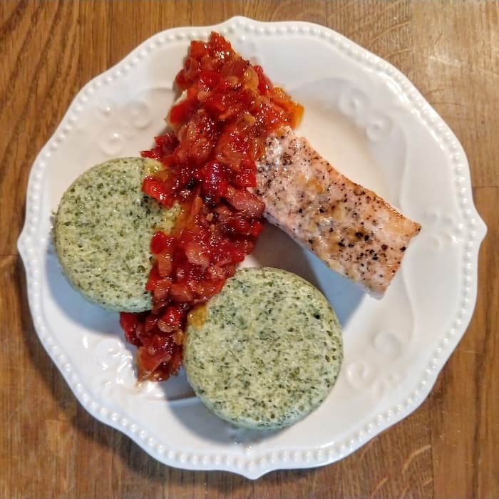 Plate with salmon, broccoli mousse, and tomato bacon jam